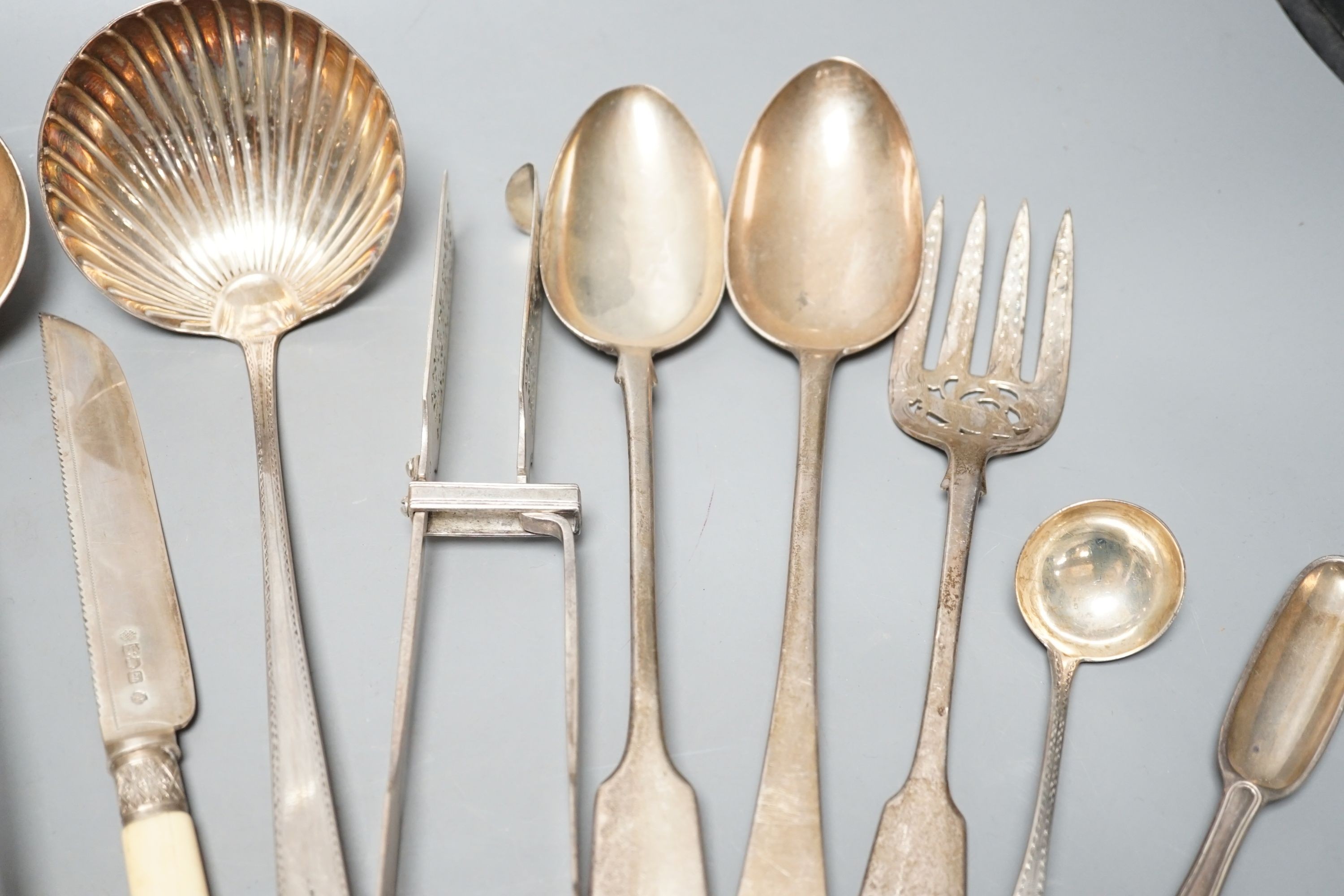A George III Irish silver Celtic tip soup ladle, Dublin, 1789, A Georgian Irish silver marrow scoop, by William Walsh, two later Victorian silver soup ladles, a pair of Victorian silver asparagus tongs, two silver bastin